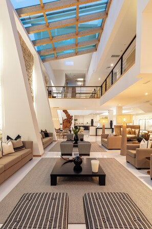 A spacious, multi-level hotel lobby with a high ceiling, a central seating area, and a reception desk. - Vila Valverde Design and Country Hotel (Lagos)