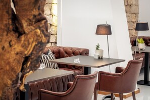Un espace repas moderne, avec des meubles en cuir, un mur en pierre et un design minimaliste.