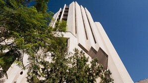 A tall, modern building with a unique architectural design, featuring vertical lines and a prominent central section. - King Solomon (Jerusalem)