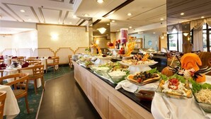 A buffet with various dishes, wooden chairs, and a ceiling with recessed lighting. - King Solomon (Jerusalem)