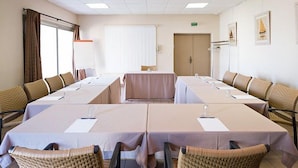 A conference room with long tables, chairs, and a large window. - Hotel Paradou (Avignon)