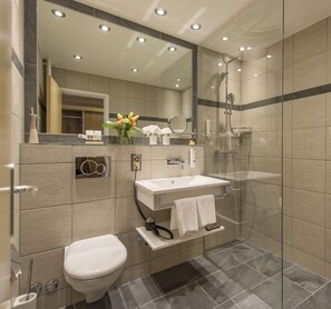 A modern bathroom with a toilet, sink, and shower. - Sunstar Hotel Arosa (Arosa)