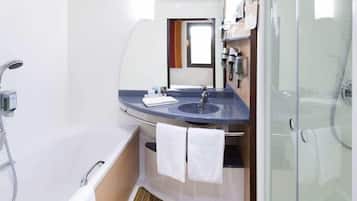 Un baño pequeño con bañera, lavabo, espejo y ducha.