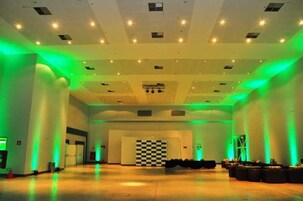 Un espacio interior amplio con un diseño de piso a cuadros, iluminación empotrada y una decoración de pared también a cuadros.
