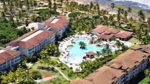 A resort with a central pool, multiple buildings, and surrounding palm trees. - Sauipe Pousadas (Mata de São João)