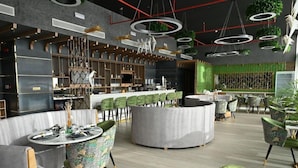 A modern interior with round tables, green chairs, and a bar area. - Savoy Grande Hotel & Spa (Manama)