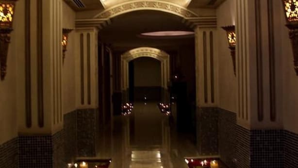 A corridor with a reflective floor, decorative lighting, and patterned walls. - Savoy Grande Hotel & Spa (Manama)