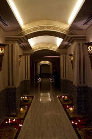 A corridor with a reflective floor, decorative lighting, and patterned walls. - Savoy Grande Hotel & Spa (Manama)