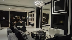 A modern living room with a sofa set, a coffee table, and a chandelier. - Savoy Grande Hotel & Spa (Manama)