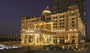A grand hotel with a prominent dome and multiple stories, featuring a well-lit facade and a landscaped courtyard. - Al Habtoor Palace (Dubai)