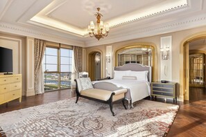 A luxurious bedroom with a large bed, a television, a view of the city, and a chandelier. - Al Habtoor Palace (Dubai)