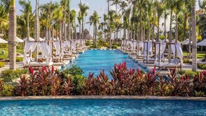 A pool with lounge chairs and palm trees. - Secrets Royal Beach Punta Cana - Adults Only (Punta Cana)