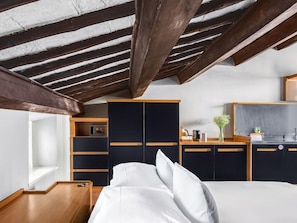A bedroom with a bed, a wardrobe, a desk, and a kitchenette. - Numa Rome Vici (Rome)
