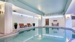 Una piscina con sillas de descanso y plantas en macetas, un cartel que indica '46' sin clavados, y suelo de baldosas.