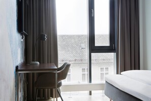 Una habitación de hotel con escritorio, silla y cama.