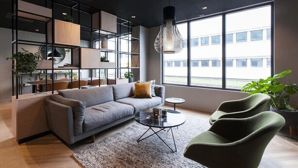 Ein modernes Wohnzimmer mit einer Couch, einem Couchtisch und einer Pendelleuchte.
