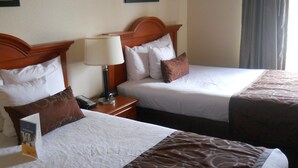 Two adjacent hotel beds with headboards, a bedside table with a lamp, and a framed picture on the wall. - Best Western Windsor Inn & Suites (Danville)