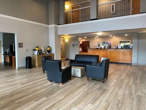 A hotel lobby with a reception desk, seating area, and a staircase. - Best Western Windsor Inn & Suites (Danville)