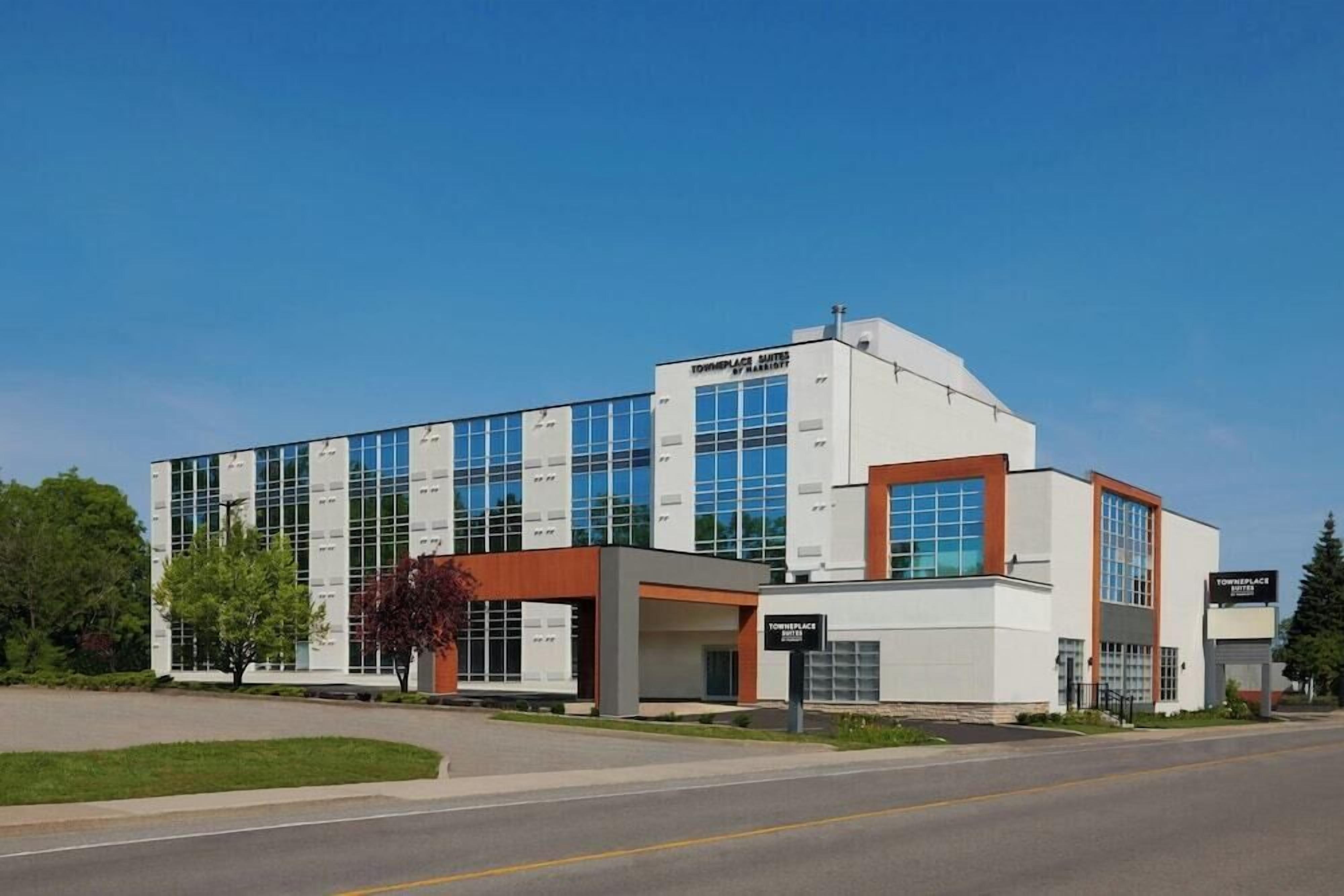 A modern building with a glass facade, a prominent entrance, and a sign indicating it's a hotel.