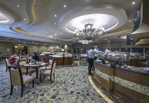 A hotel lobby with a central bar area, seating arrangements, and a chandelier. - Corp Al Khobar Corniche Hotel (Al Khobar)