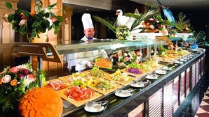 A buffet with various food items and a chef in the background. - Occidental Marco Polo (Hammamet)