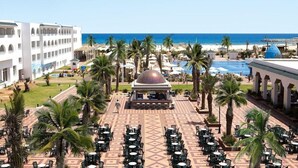A resort with a pool, palm trees, and a beach view. - Occidental Marco Polo (Hammamet)
