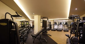 Ein Fitnessstudio mit verschiedenen Trainingsgeräten, darunter Laufbänder und Kraftgeräte.