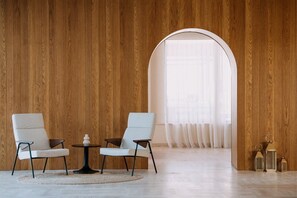 A modern interior with two chairs, a small table, and a round rug. - Aulus Chania Resort, Curio Collection by Hilton (Chania)