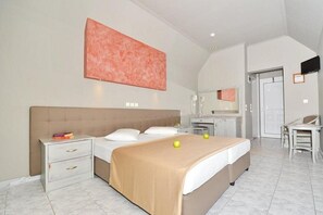 A bedroom with a bed, bedside tables, a desk, and a chair. - Sousouras Beach Hotel and Bungalows (Kassandra)
