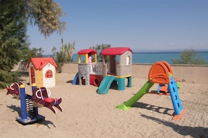 Juegos infantiles al aire libre con tobogán, estructuras para escalar y columpios.
