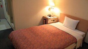 A hotel room with a bed, a nightstand, a lamp, and a telephone. - Ascent Inn Sapporo (Sapporo)