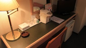 A hotel room desk with a lamp, a coffee maker, a television, and a small refrigerator. - Ascent Inn Sapporo (Sapporo)