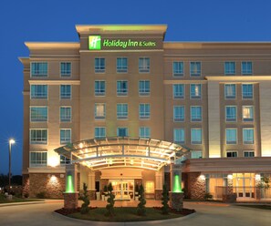 Holiday Inn & Suites -hotellin rakennuksessa on lasinen sisäänkäynti, useita ikkunoita ja kivestä tehty julkisivu.