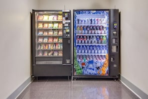 Two vending machines with snacks and beverages, a payment terminal, and a push button.