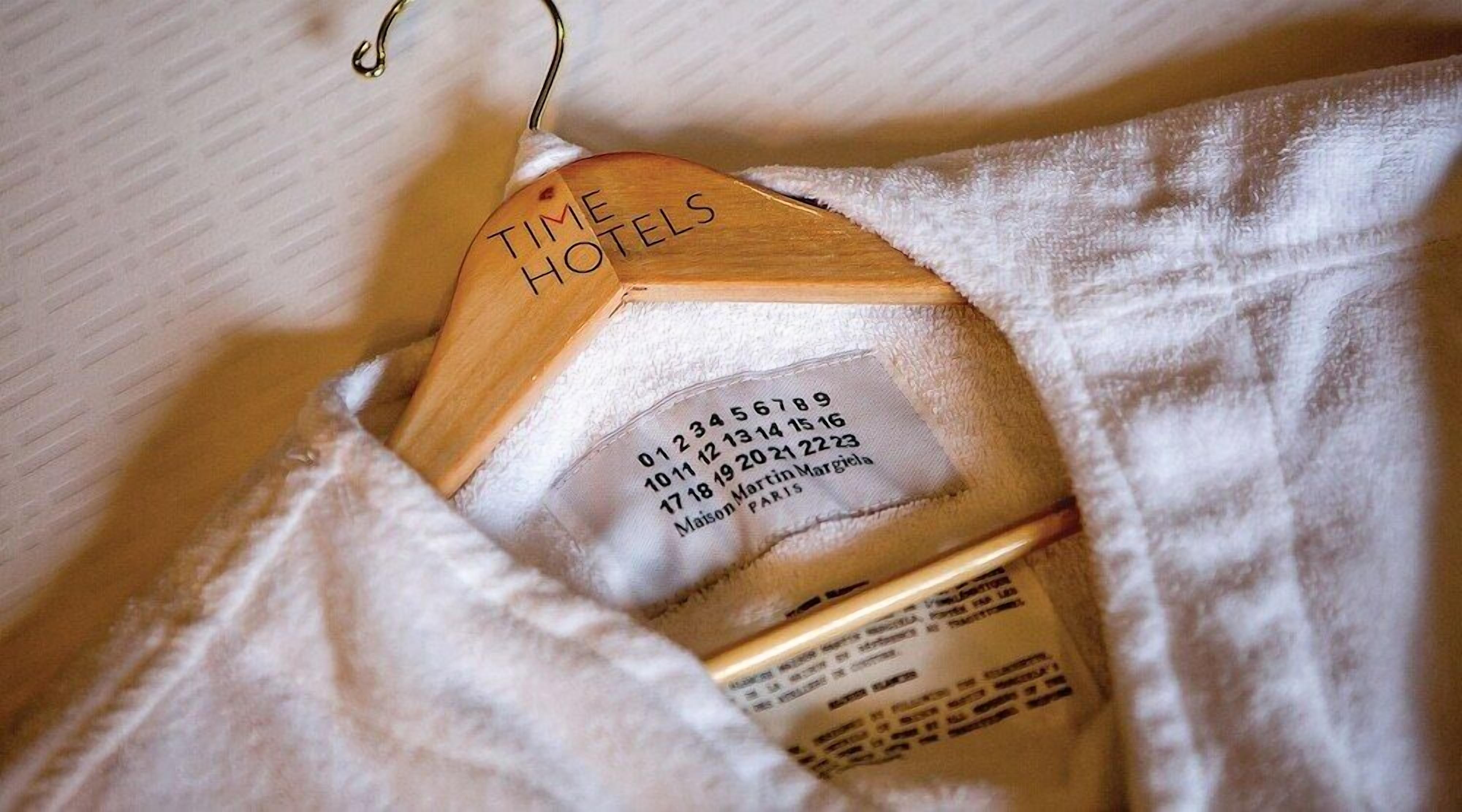 A wooden hotel sign with contact information and address.