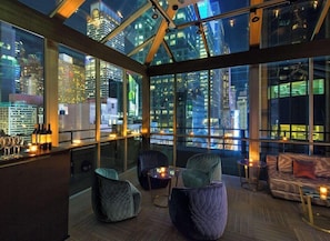 A modern interior with a city view, a bar area, and seating. - The Time New York (New York)