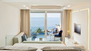Ein modernes Hotelzimmer mit großem Balkon, einem Bett, einem Fernseher und Meerblick.