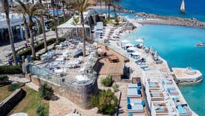 Ein Resort mit Außenbestuhlung, einem Pool und Meerblick.