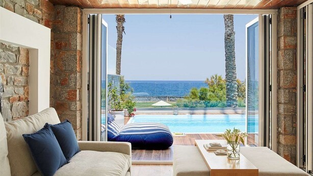 Ein Zimmer mit Meerblick, einem Pool und einer Holzbalkendecke.