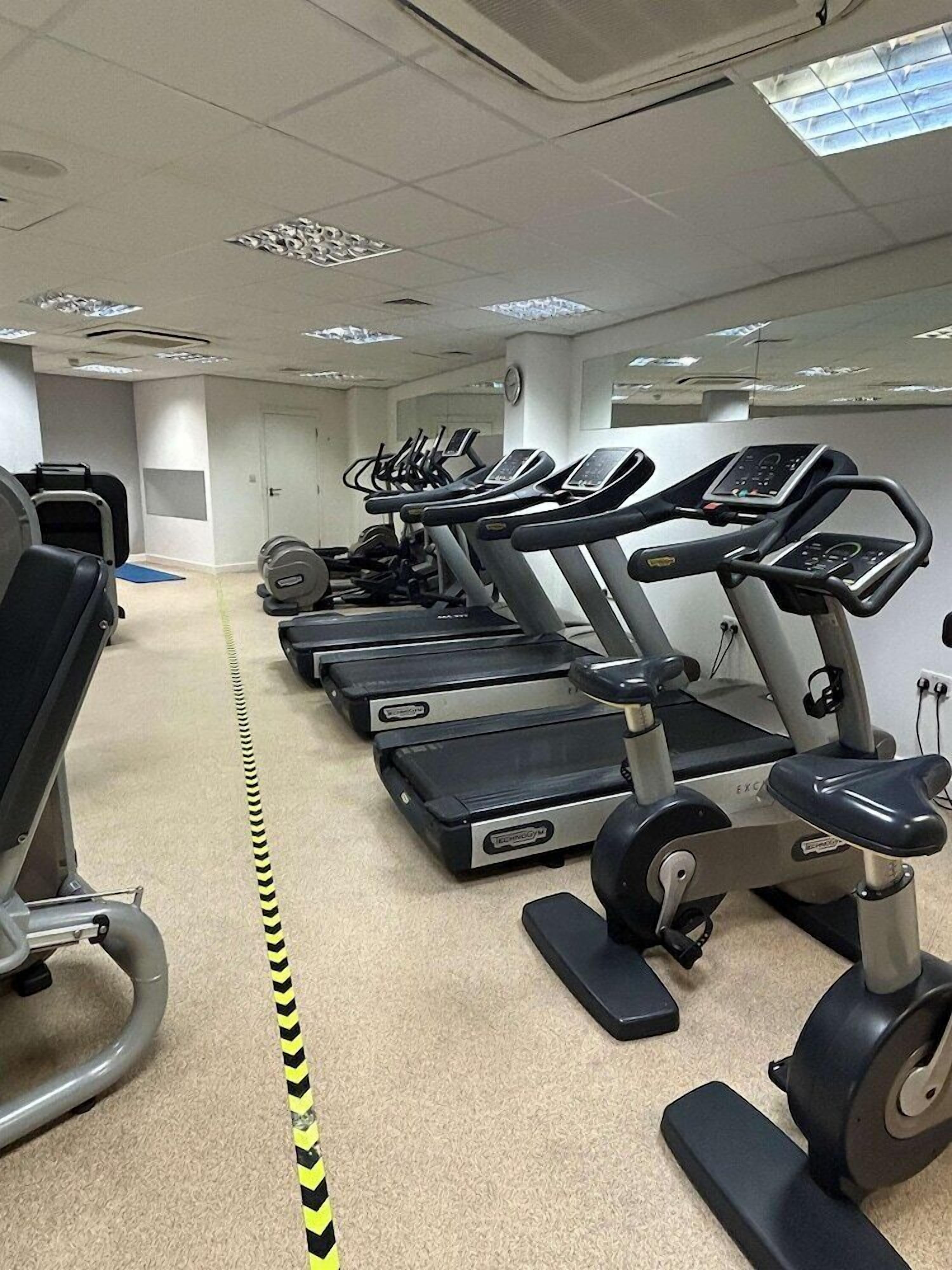 A gym with treadmills, exercise bikes, and weight machines.