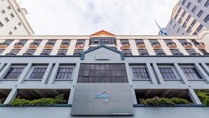 Un edificio moderno con el letrero Club Dolphin, varios balcones y cielo despejado.