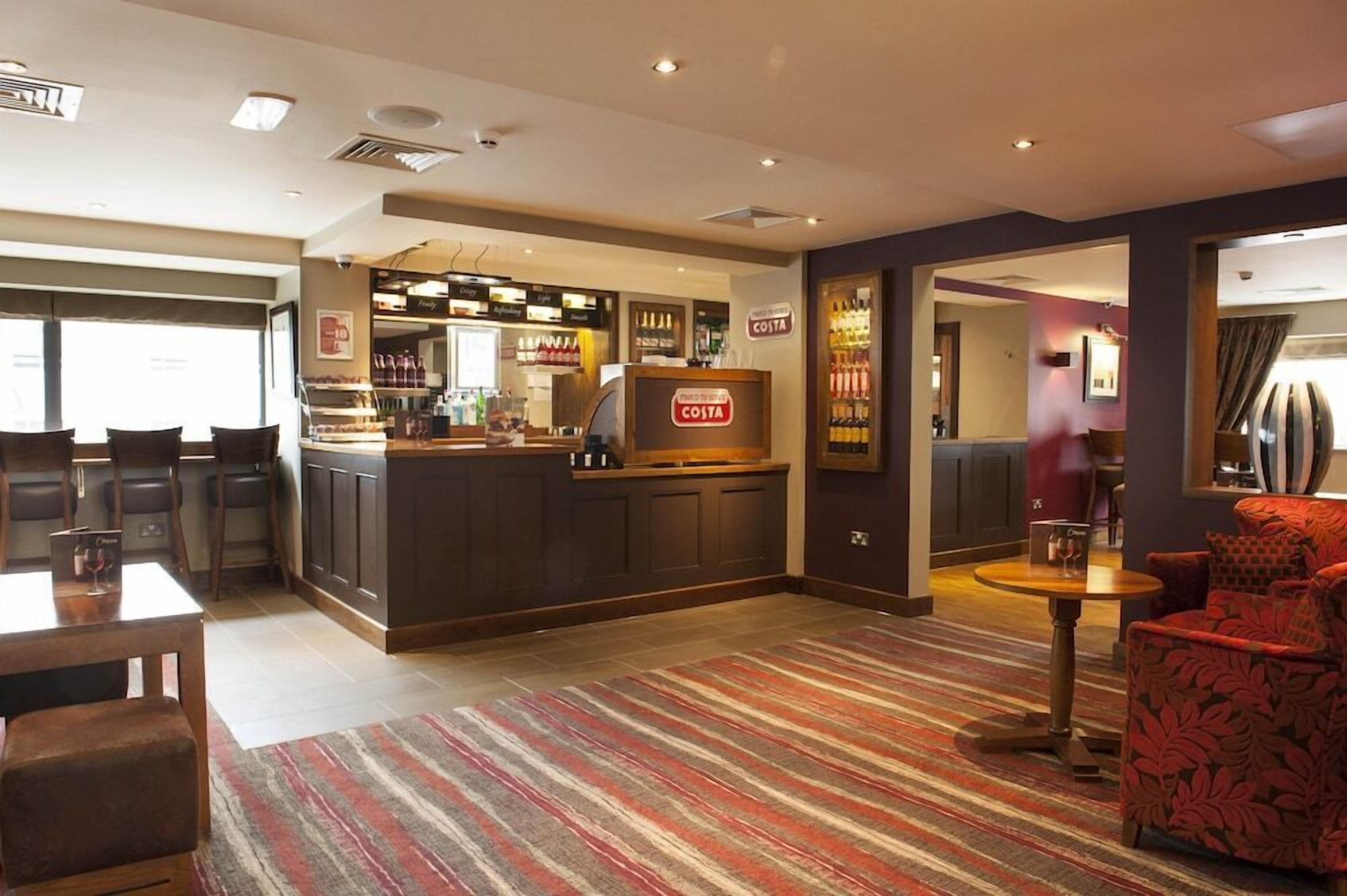 A hotel lobby with a bar area, seating, and a Costa sign.