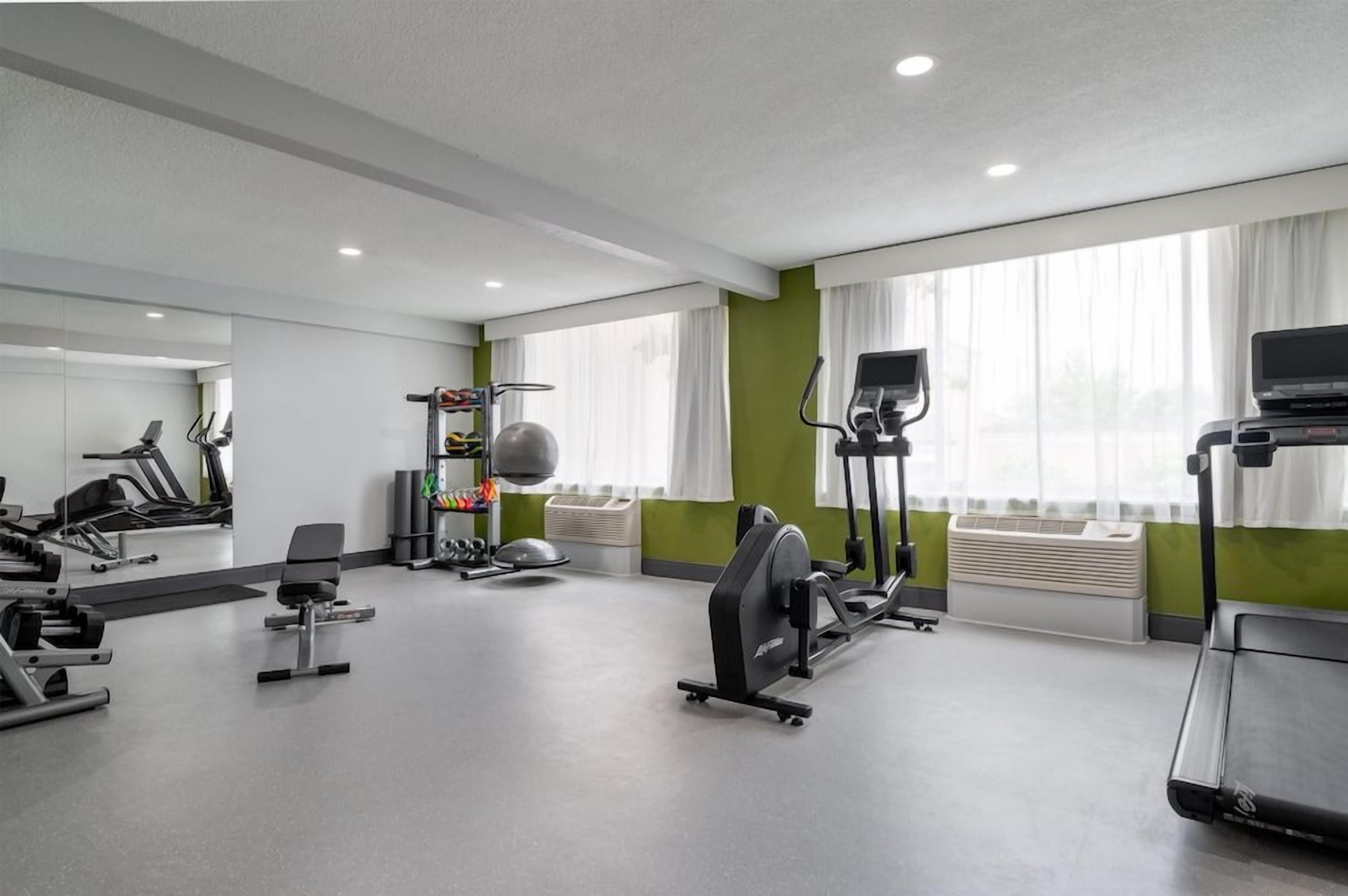 A gym with various exercise equipment, including treadmills, stationary bikes, and weight machines.