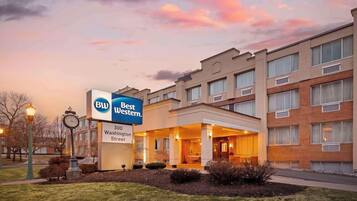 A Best Western hotel with a sign, a clock, and a well-lit entrance.