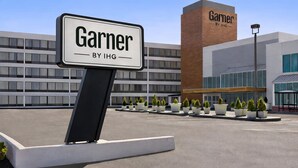 A sign for 'Garner by IHG' in front of a modern building with multiple windows and a brick facade. - Wyndham Garden Totowa (Totowa)