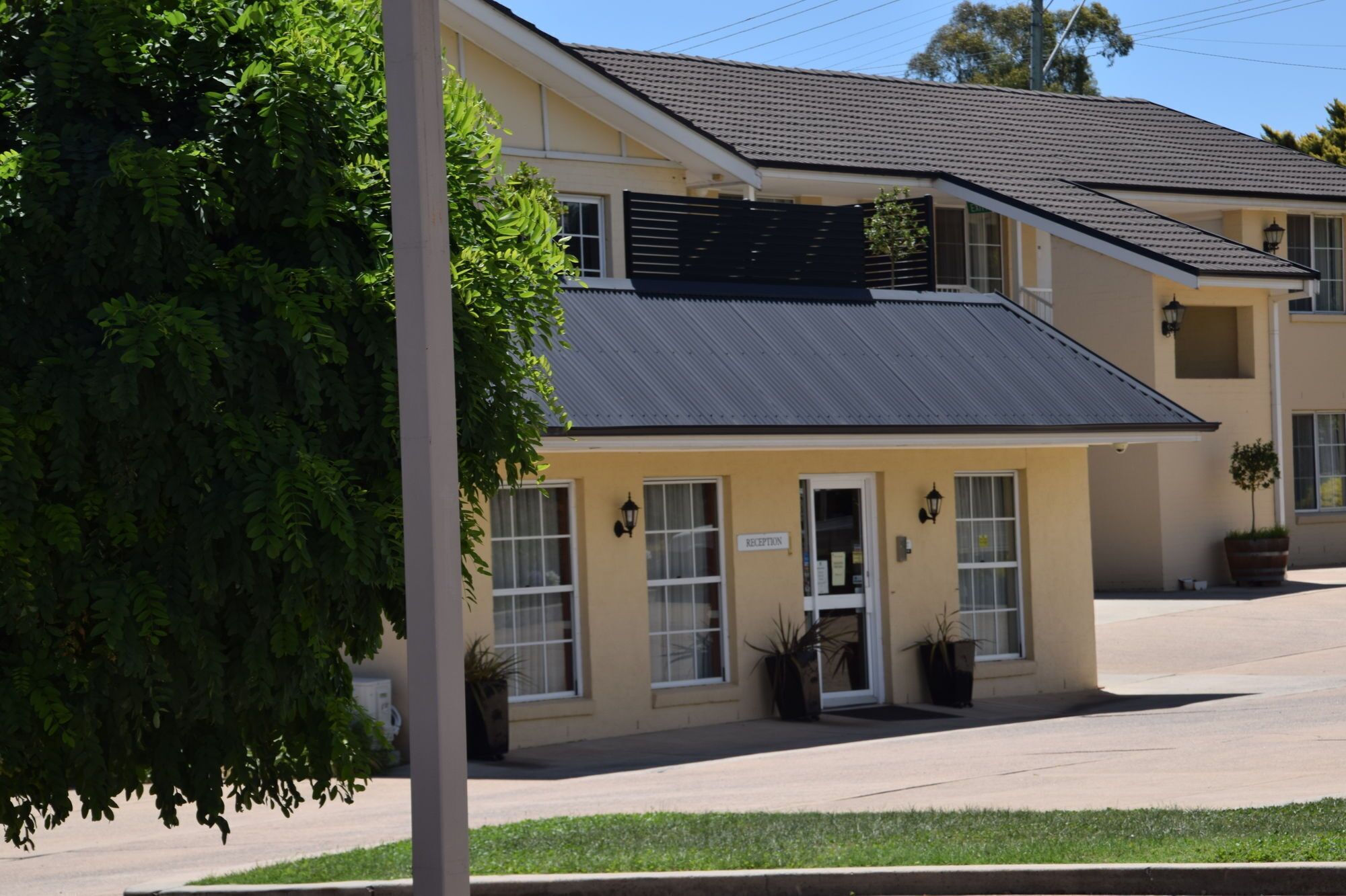 A two-story building with a reception area, a covered entrance, and a small garden.