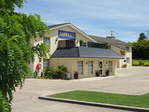 Ein Motel mit Schild, Rezeption und Parkplatz.