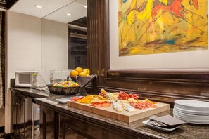 Ein Buffet mit verschiedenen Speisen, einer Mikrowelle und einem Bild an der Wand.