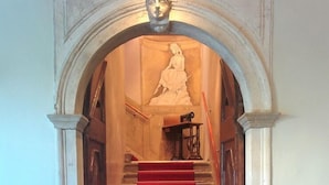 Eine Treppe mit rotem Teppich, der zu einem Raum mit einer weißen Tür führt.