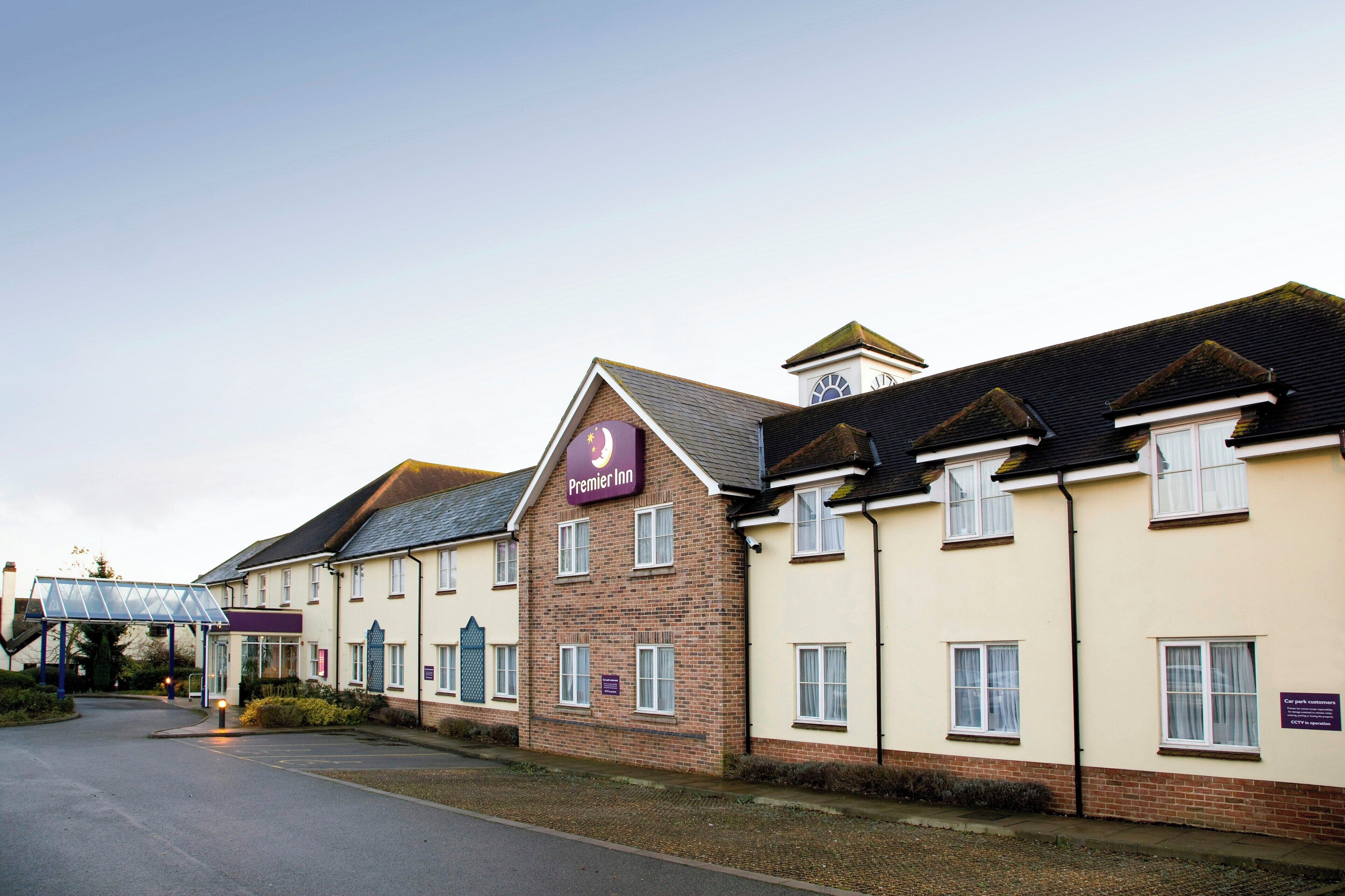 Een hotel met een opvallend Premier Inn bord, een overdekte ingang en een gevel van baksteen.